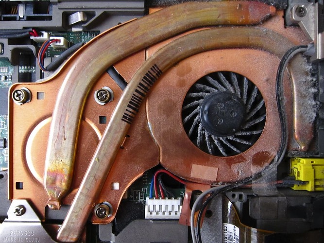 What are the signs that my laptop's cooling system needs maintenance?